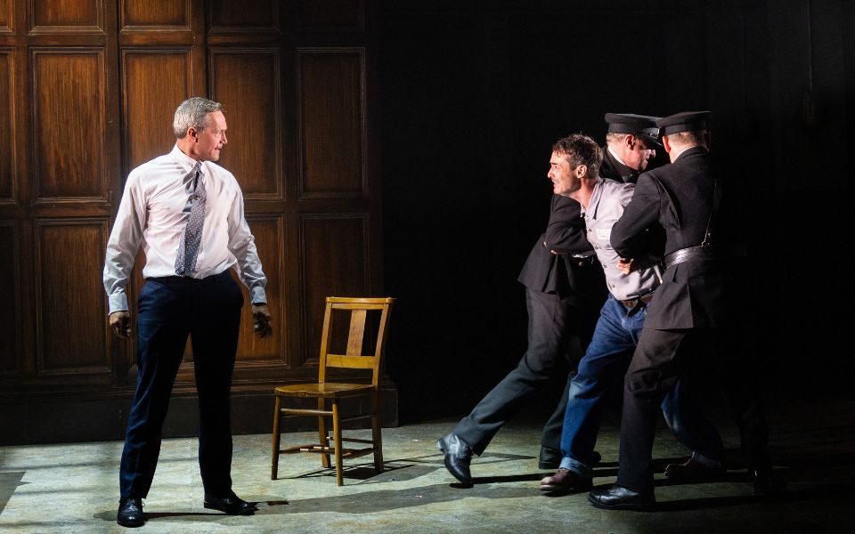 Prison wardens hold back Joe McFadden as Andy Dufresne who lunges towards Bill Ward as Warden Stammas.
