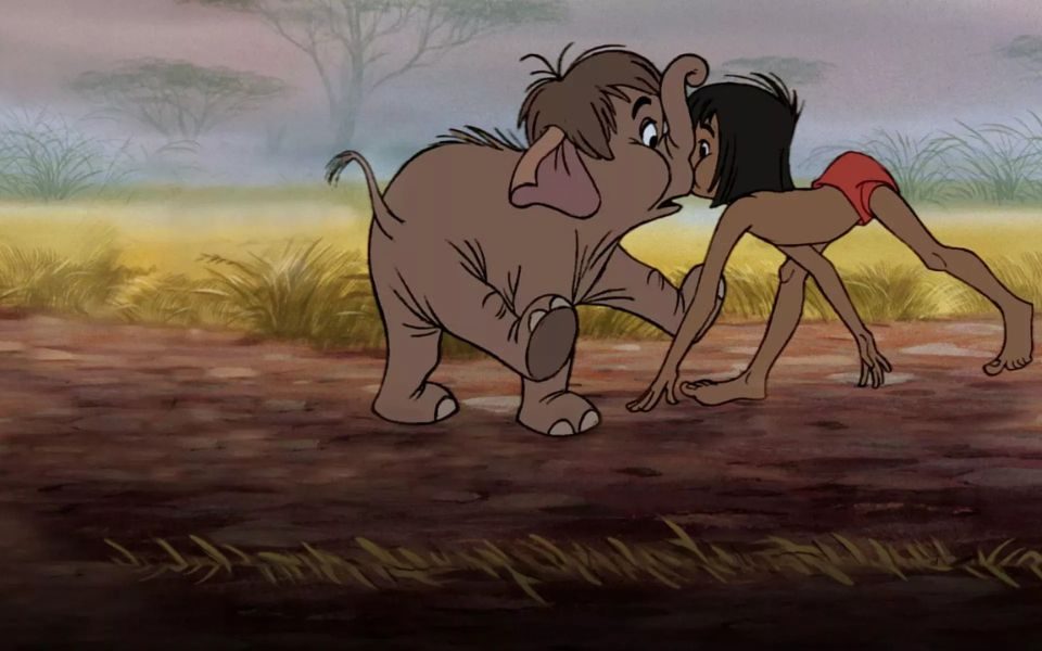 Animated still. In the bushland, baby elephant and a child crawling on all fours collide head first.