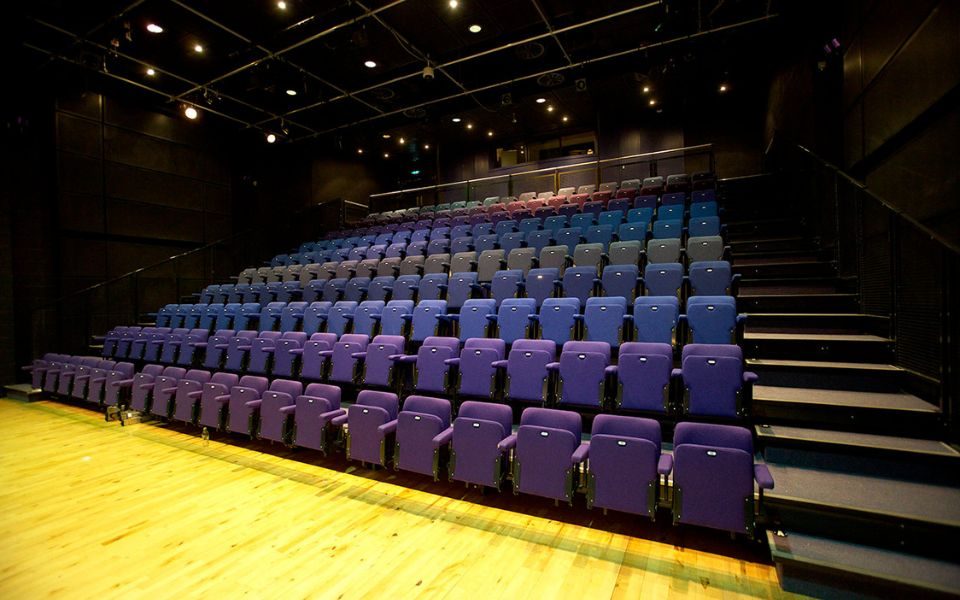 The auditorium at Birmingham Hippodrome featuring rows of blue seats.