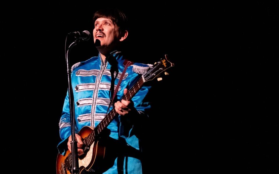 A musician performs as Paul McCartney in a classic Sgt. Pepper's Lonely Hearts Club Band costume