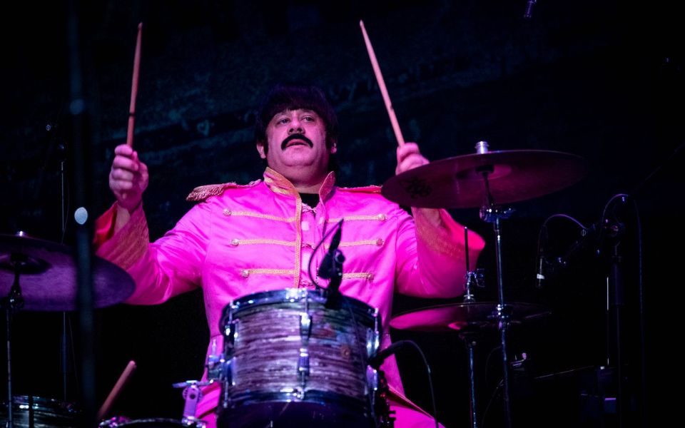 A musician performs as Ringo Starr in a classic Sgt. Pepper's Lonely Hearts Club Band costume