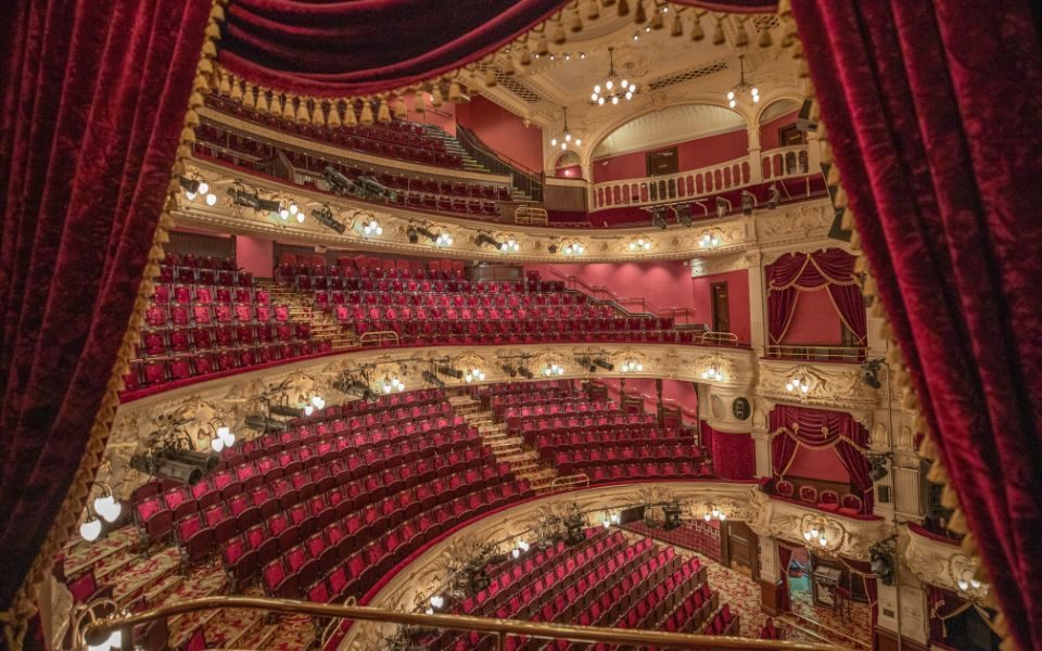 The fours levels of the auditorium at Newcastle Theatre Royal with rows of red seats.