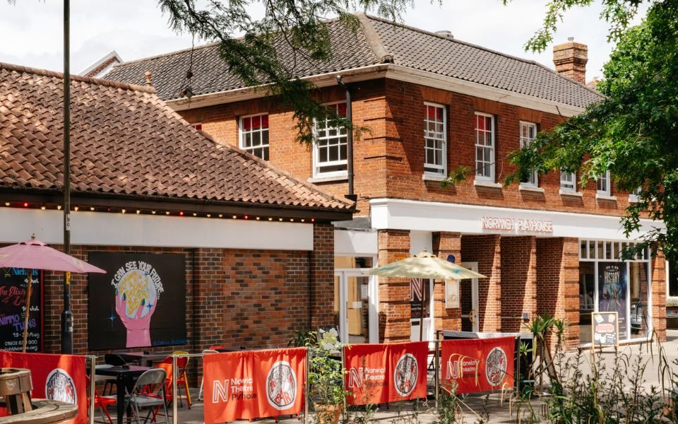 The exterior of Norwich Playhouse with outdoor bar seating cordoned off outside.