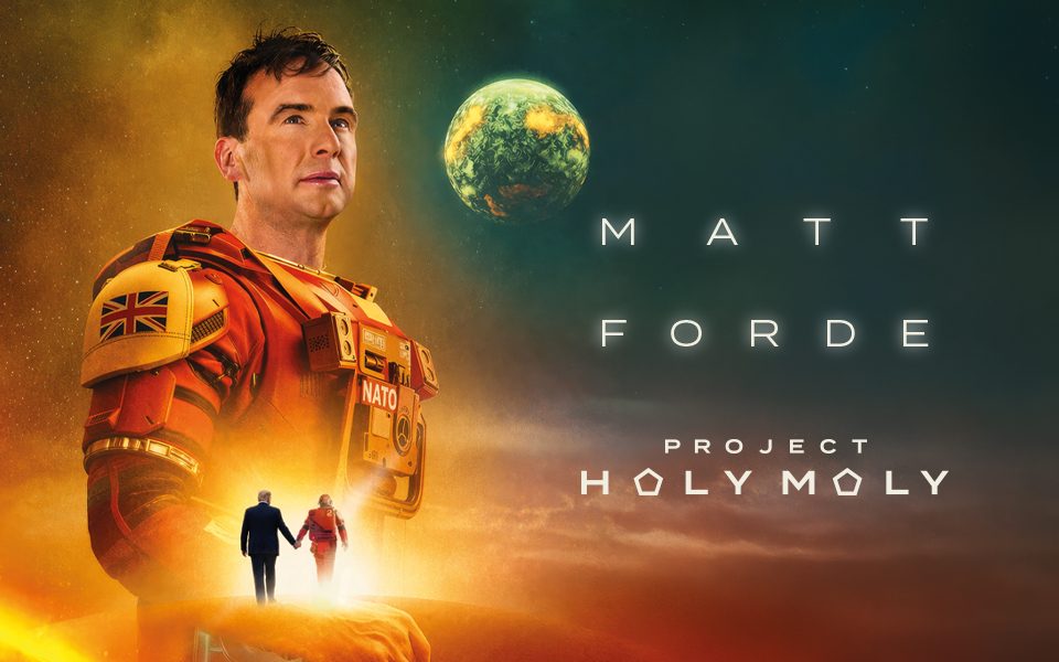 In the style of a sci-fi movie poster, Matt Forde stands proudly in a red space-suit, looking off into the distance. In front of him, there is a silhouette of an astronaut and Donald Trump walking hand-in-hand towards a bright light. Text reads: Project Holy Moly.