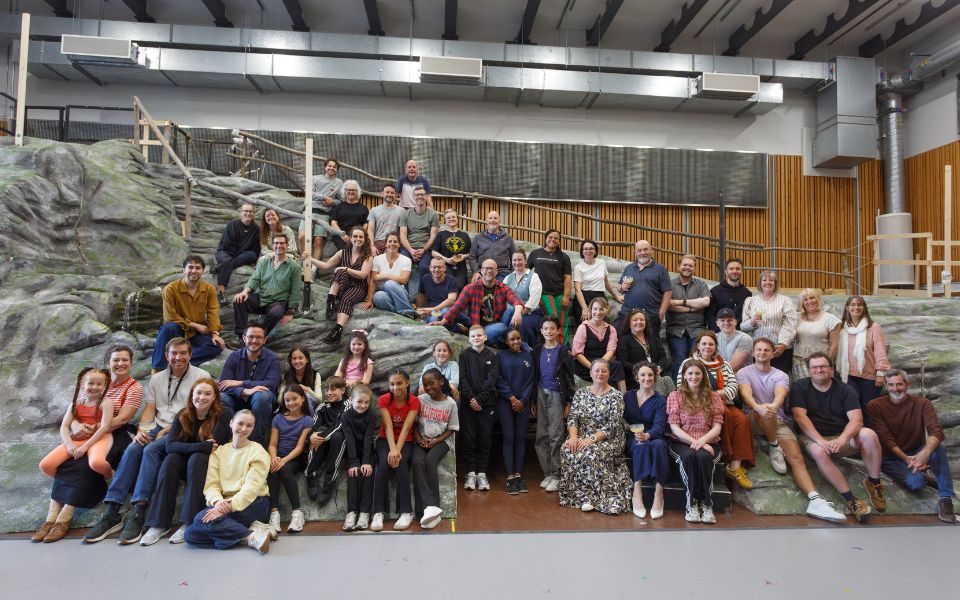 The cast of The Sound of Music gathered on the grey mountain set in the rehearsal studio.