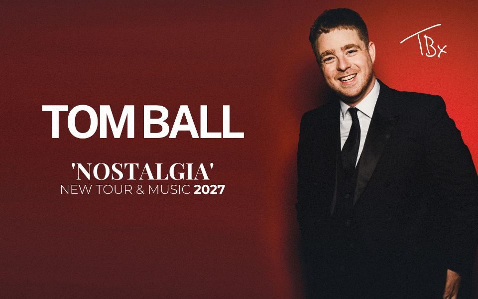 Tom Ball in a suit smiling, with hands casually in his pockets against a red backdrop. Text reads: Tom Ball: Nostalgia. New tour and music 2027.