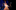 Two actors playing Belle and the Beast are ballroom dancing on stage beneath a spotlight.