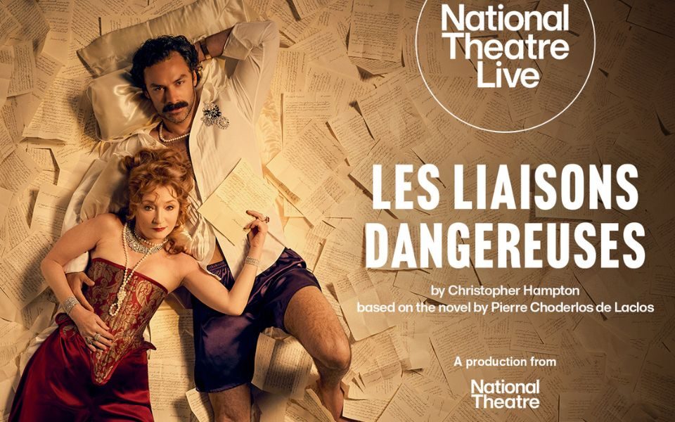 A woman in pearls, diamond jewellery and a red and gold corset lies on a moustached man in an unbuttoned shirt and shorts. Both look up at the camera and lie across sheets of handwritten notes. Text reads: National Theatre Live. Les Liaisons Dangereuses by Christopher Hampton based on the novel by Pierre Choderlos de Laclos. A production from National Theatre.