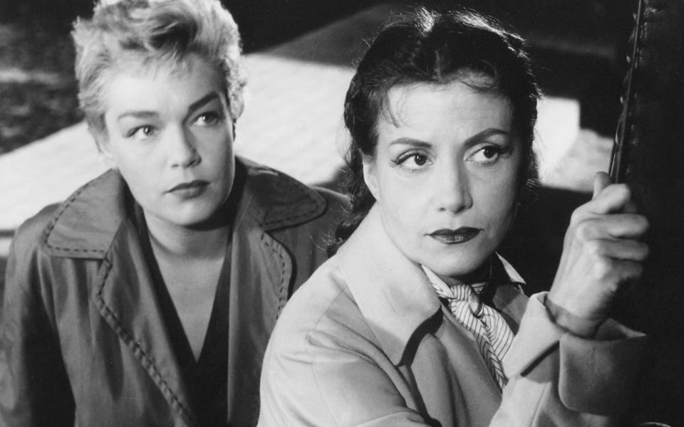 A black-and-white image of two women looking intently at something off-camera.