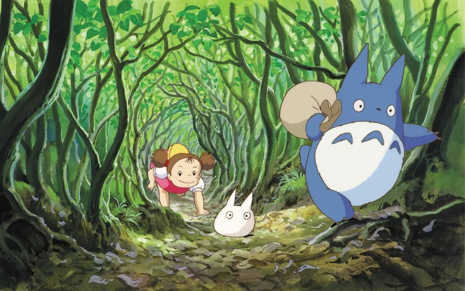 Animated characters including a large furry blue creature, a small white creature and a young girl running together through a woodland scene.